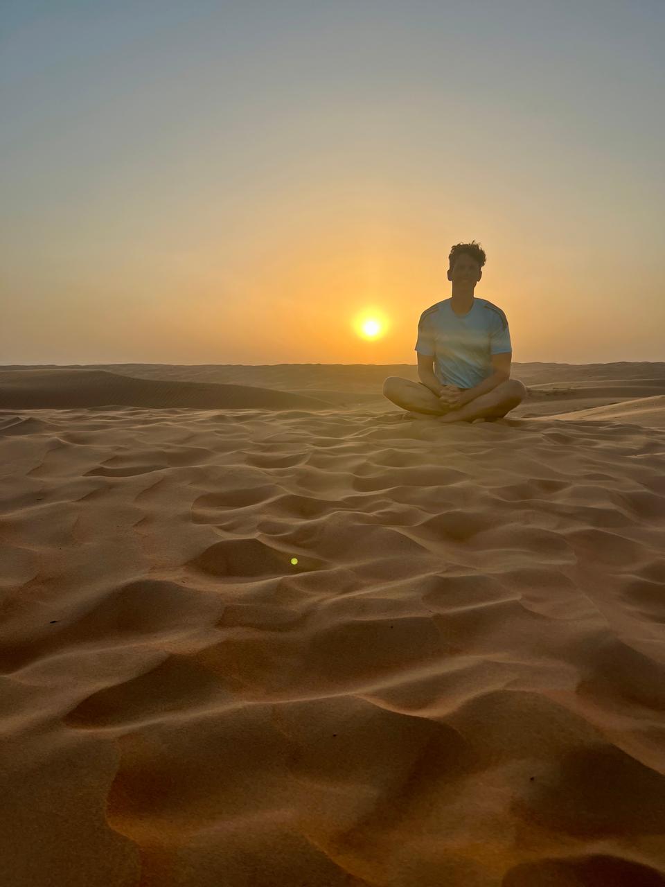 Traveller sitting on the dunes at sunset, Bidiya (Wahiba) Sands